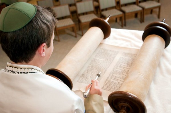A 13-year-old Jewish lad reads from the Torah scroll using a yad (Torah pointer, literally hand) Bar Mitzvah-Torah Scroll-Reading