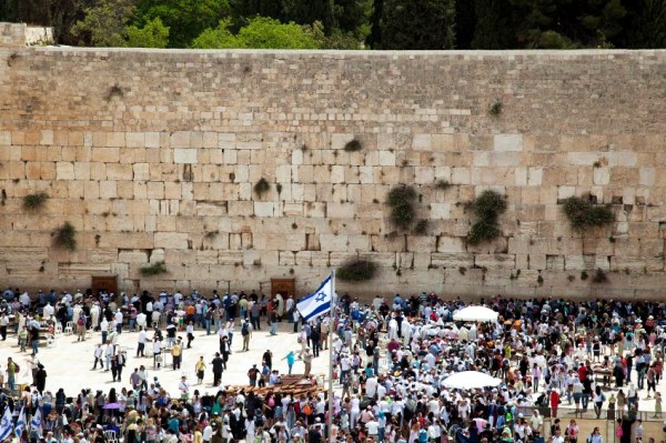 The Western (Wailing) Wall in Jerusalem is a remnant of the wall that surrounded the Jewish Temple's courtyard. Kotel-Western Wall-Israel flag-crowds