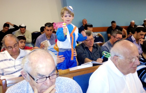 A Jewish boy spins his grogger in the synagogue as he hears Haman's name during the reading of the Megillat. A Jewish boy spins his grogger in the synagogue as he hears Haman's name during the reading of the Megillat.