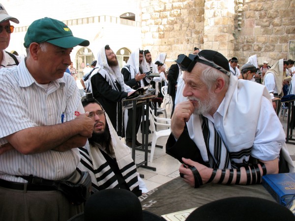 A Palestinian Christian and a Jewish Orthodox man have a discussion at the Western (Wailing) Wall in Jerusalem. A Palestinian Christian and a Jewish Orthodox man have a discussion at the Western (Wailing) Wall in Jerusalem.