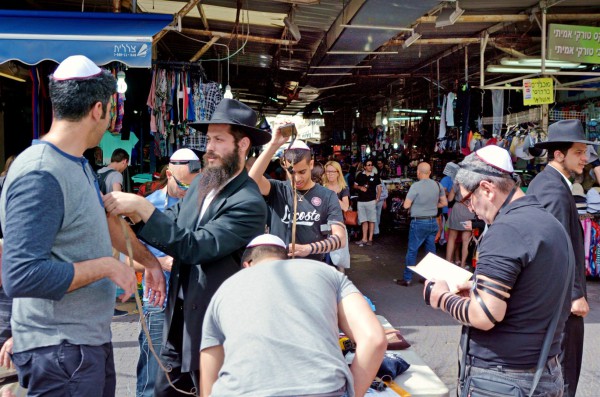 Ultra-Orthodox Jewish men in Tel Aviv show passersby how to put on tefillin (phylacteries) and pray. Ultra-Orthodox Jewish men in Tel Aviv show passersby how to put on tefillin (phylacteries) and pray.